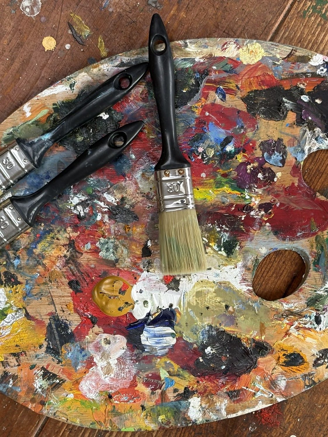 Palet met verf en kwasten in het atelier